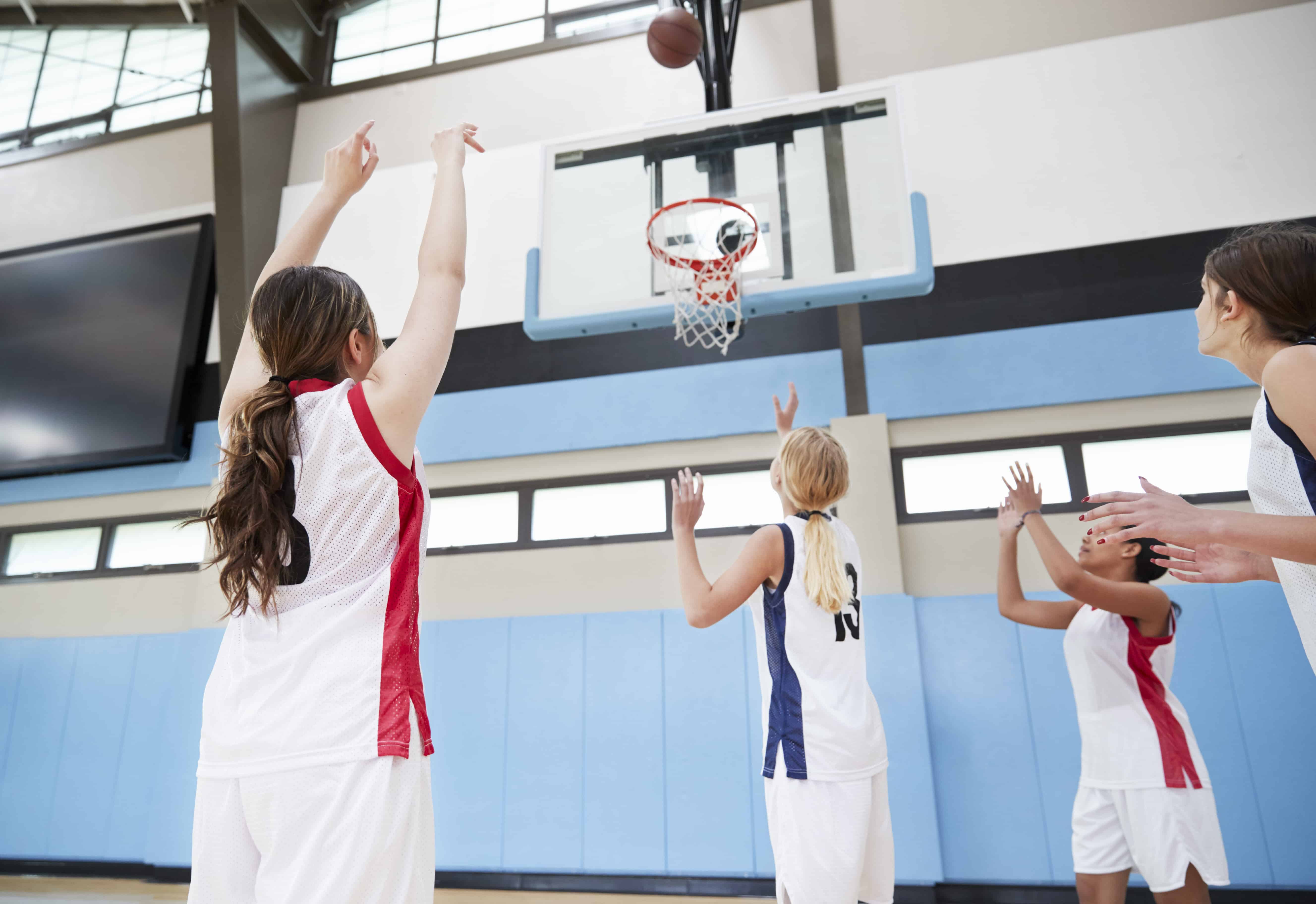 Female High School Basketball Team Shooting At Basket On Court